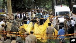 Indian police officers prepare to cover the scene of a blast outside the High Court in New Delhi, India, September 7, 2011.