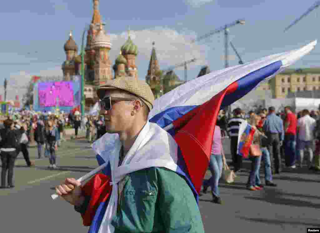 People walk with flags and banners near Red Square during a rally in Moscow, May 1, 2014. 