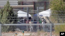 Detainees are seen at a facility where tent shelters are being used to house separated family members at the Port of Entry, June 21, 2018, in Fabens, Texas.
