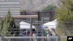 被拘留人员出现在德克萨斯州用于收纳被拆散家庭的帐篷前。（2018年6月21日）