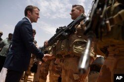 FILE - French President Emmanuel Macron, visits soldiers of Operation Barkhane, France’s largest overseas military operation, in Gao, Northern Mali, May 19, 2017.