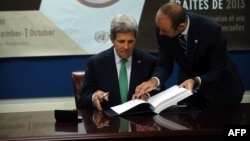 U.S. Secretary of State John Kerry signs the U.N. Arms Trade Treaty at U.N. headquarters in New York City September 25, 2013. Standing beside him is U.N. Under Secretary General for Legal Affairs Miguel de Serpa Soares.
