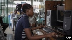 Les clients surfent sur Internet dans un cybercafé le 25 février 2015 à Kinshasa.