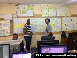 Kiro'o Games Games Designer Dominique Yakan and Chief Executive Officer Olivier Madiba pose in front of the team's ideas wall in Kiro'o headquarters, Yaounde, Cameroon, July 10, 2018.