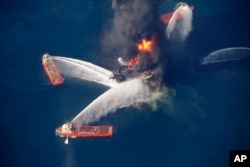 FILE - The Deepwater Horizon oil rig burns in the Gulf of Mexico, April 21, 2010, after an explosion that killed 11 workers and caused the worst offshore oil spill in the nation's history.