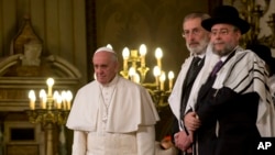 Pope Francis, left, flanked by Rabbi Riccardo Di Segni, listens to a chorus at the end of his visit to the Great Synagogue of Rome, Jan. 17, 2016. It was his first visit to a synagogue as pope.