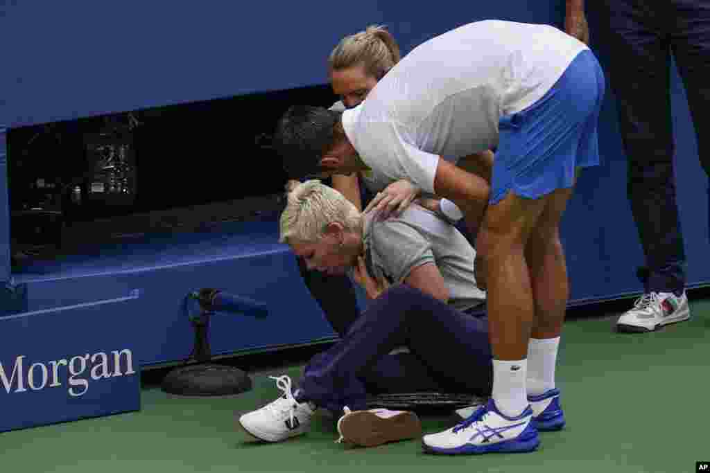 Novak Djokovic of Serbia checks a linesman after hitting her with a ball in reaction to losing a point to Pablo Carreno Busta of Spain during the fourth round of the US Open tennis championships in New York, Sept. 6, 2020. Djokovic defaulted the match.
