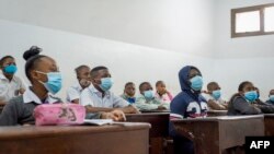 Les élèves portent des masques faciaux dans leur classe à l'école du révérend Kim, site Lingwala, à Kinshasa le 10 août 2020, à la reprise des cours après le verrouillage du coronavirus Covid-19. (Photo by Arsene Mpiana / AFP)