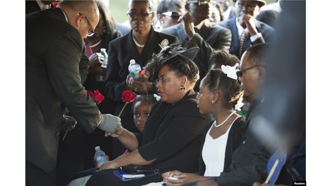 Jennifer Pinckney accepts a rose at the burial of her husband, the Reverend Clementa Pinckney, at the St James AME Church Cemetery in Marion, South Carolina, June 26, 2015.