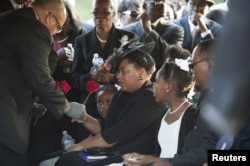 Jennifer Pinckney accepts a rose at the burial of her husband, the Reverend Clementa Pinckney, at the St James AME Church Cemetery in Marion, South Carolina, June 26, 2015.