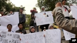 FILE - A Sept. 2014 photo shows protesters holding posters during a rally against the Islamic State group, in Jakarta, Indonesia.