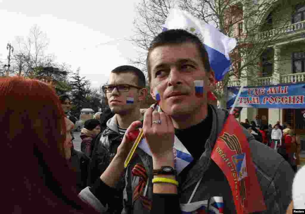 ایک آدمی اپنے چہرے پر روس کا پرچم بنوا رہا ہے۔