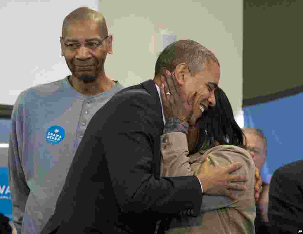Presiden Barack Obama dipeluk oleh salah seorang sukarelawan pada saat mengunjungi kantor kampanye kubu Obama di Chicago (6/11).
