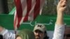 A protest leader unfurls a Syrian flag in front of the White House Saturday, seeking more U.S. action to protect civilians in Syria.