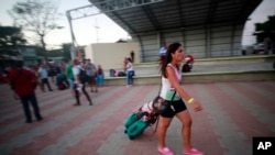 Seorang migran dari Kuba berjalan menuju bis yang akan mengantar mereka ke bandara di La Cruz, Kosta Rika (12/1).