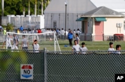 FILE- Immigrant children play outside a former Job Corps site that now houses them in Homestead, Fla., June 18, 2018.