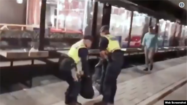 瑞典警察将一名在旅社中闹事的曾姓中国游客抬出旅社（推特图片）
