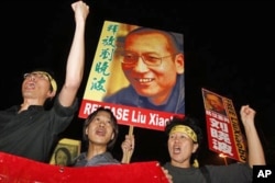 FILE - Pro-democracy protesters raise pictures of Chinese dissident Liu Xiaobo with Chinese words reading: "Release Liu Xiaobo" during a demonstration outside the China's Liaison Office in Hong Kong, Oct. 8, 2010.