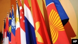 FILE - The Association of the Southeast Asian Nations (ASEAN) flag, right, leads the flags of the 10 member countries during the ASEAN Regional Forum meeting in Singapore.