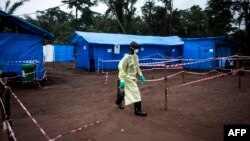 A health worker walks at an Ebola quarantine unit, June 13, 2017 in Muma, DRC, after a case of Ebola was confirmed in the village.