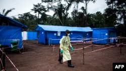 FILE - A health worker walks at an Ebola quarantine unit, June 13, 2017 in Muma, DRC, after a case of Ebola was confirmed in the village.