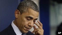 President Barack Obama wipes his eye as he speaks about the elementary school shooting in Newtown, Connecticut, Friday, Dec. 14, 2012, in the briefing room of the White House.