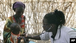 A Turkana woman holds a young child as both are examined for malnutrition by a World Vision nurse at a feeding and treatment center in Lokori, Kenya, July 28, 2011