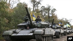 FILE - Ukrainian tanks move near Mariupol, Donetsk region, eastern Ukraine, Oct. 21, 2015.