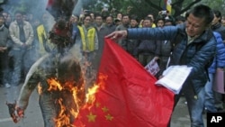 Tibetan exiles burn a Chinese flag and an effigy representing a Chinese official during a protest in New Delhi, January 17, 2012.