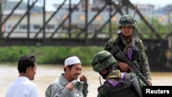 Tentara Thailand memeriksa warga di sebuah pos di propinsi Yala (28/2). Sehari setelah pemerintah Thailand menyepakati dimulainya perundingan dengan kelompok pemberontak muslim untuk pertamakalinya dalam upaya mengakhiri konflik, sebuah bom meledak di Thailand Selatan, dan melukai sedikitnya enam orang (1/3).