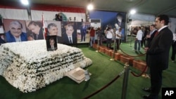 Former Lebanese Prime Minister Saad Hariri, right, the son of slain former Prime Minister Rafiq Hariri, prays at his father's grave in downtown Beirut, 09 Nov 2009