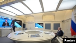 Presiden Rusia Vladimir Putin mendengarkan Presiden AS Joe Biden dalam KTT iklim virtual melalui tautan video di Moscow, Rusia, 22 April 2021. (Foto: Alexei Duzhinin/Sputnik/Kremlin via Reuters)