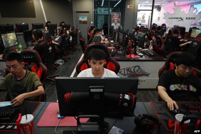 Para penggemar game online, tengah bermain di sebuah cafe internet di Beijing, 10 September 2021. (AFP)