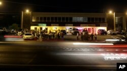 Traffic moves freely as smaller group of protesters gather along West Florissant Avenue in Ferguson, Mo., Tuesday, Aug. 11, 2015.