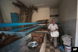 Yofel Sabbagh, 46, walks inside a bakery as he prepares Challah, a special Jewish bread, on the eve of Shabbath, at Hara Kbira, on the island of Djerba, southern Tunisia, Oct. 30, 2015.