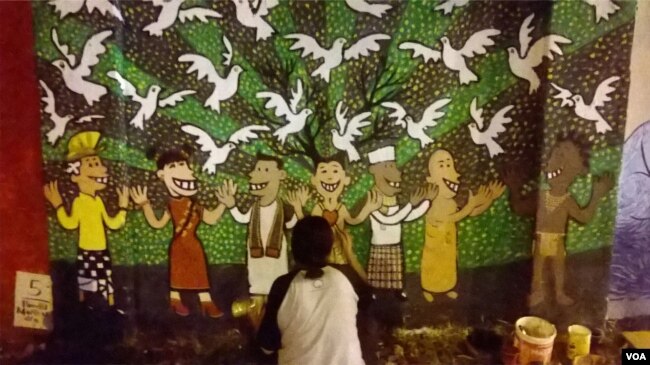 Seorang seniman mural menggambar di dinding Stadion Kridosono, Yogyakarta berisi pesan damai dan kesetaraan. (Foto: VOA/Nurhadi-dok/ilustrasi)