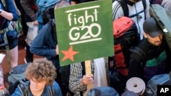A passenger of the special protest train 'ZuG20' carries a poster 'fight G20' while arriving at the central station in Hamburg, Germany, July 6, 2017.