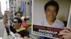 FILE - Protesters of "Students for a Free Tibet Japan" shout slogans during a demonstration to demand the release of arrested Tibetan filmmaker Dhondup Wangchen, who is pictured on the poster, in front of the Chinese Embassy in Tokyo, Aug. 1, 2009. Wangchen, jailed in China in March 2008, escaped from Tibet and joined his wife and four children in San Francisco on Dec. 25, 2017. 