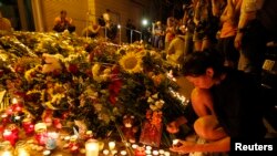 人们带着鲜花和蜡烛来到荷兰驻乌克兰基辅大使馆，悼念坠毁的马来西亚波音777客机上的遇难者。