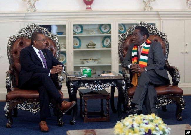 FILE - United States Ambassador to Zimbabwe Brian Nichols, left, is seen during a courtesy call with Zimbabwean President elect Emmerson Mnangagwa at his official residence State House in Harare, Aug, 15, 2018. Nichols emphasized the need to respect human rights as Zimbabwe awaits a court ruling on whether the election results are valid.