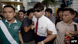 Thai policemen arrest an anti-coup protester (C) during a demonstration at a shopping mall in Bangkok, June 22, 2014. 