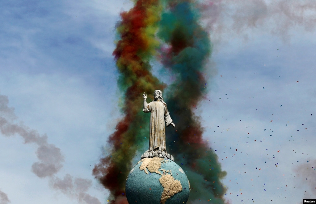 Fireworks are seen behind the monument of El Salvador del Mundo during the opening parade of the festivities of El Divino Salvador del Mundo (The Divine Savior of The World), patron saint of the capital city of San Salvador, Aug. 1, 2018.