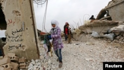 Samah, 11, helps her father by salvaging their belongings from their damaged house in Doudyan village in northern Aleppo Governate, Syria, Jan. 2, 2017.