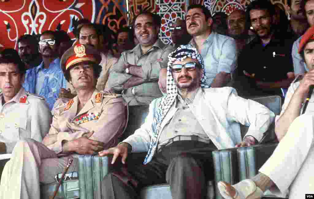 Libyan leader Colonel Moammar Gadhafi shows a parade with Palestinian PLO leader Yasser Arafat, 26 August 1978 in Tripoli, Libya, (AFP).