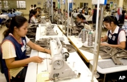 FILE - Cambodian garment workers sew clothes in a factory in Phnom Penh, Cambodia, Aug. 4, 2007.