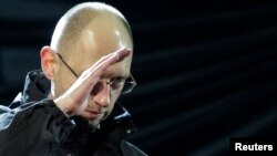 Ukraine opposition leader Arseniy Yatsenyuk, named to the post of interim prime minister, gestures on the stage during a rally in Independence Square in Kyiv, Feb. 26, 2014.
