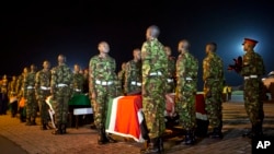 Military pallbearers stand to attention next to the coffins of four Kenyan soldiers who were killed in Somalia, at a ceremony to receive their bodies which were airlifted to Wilson Airport in Nairobi, Kenya, Jan. 18, 2016.