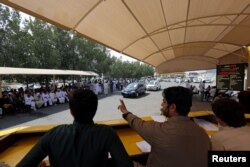 FILE - People take part in an auction of used cars at Al Aweer Market in Dubai, UAE, April 8, 2018.