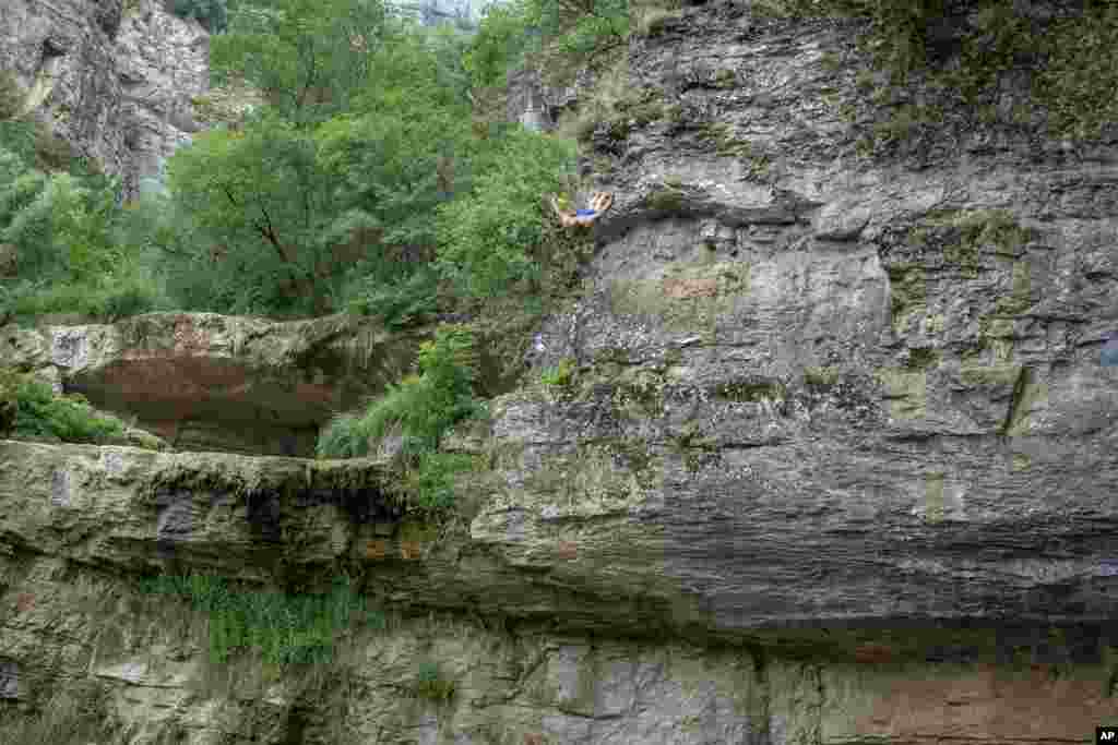 Shkelzen Goqi dives from a 17-meter waterfall during a high diving competition from Mirusha waterfalls near the village Llapceve, Kosovo, July 12, 2020.