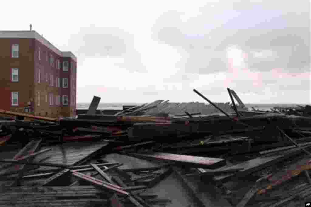 Large chunks of the boardwalk are piled near an apartment building on the ocean in Atlantic City, N.J., Tuesday, Oct. 30, 2012.